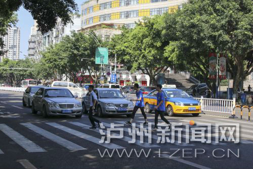 四川警察學(xué)院前的斑馬線沒有紅綠燈，但過往車輛見到有行人過斑馬線都會(huì)禮讓行人